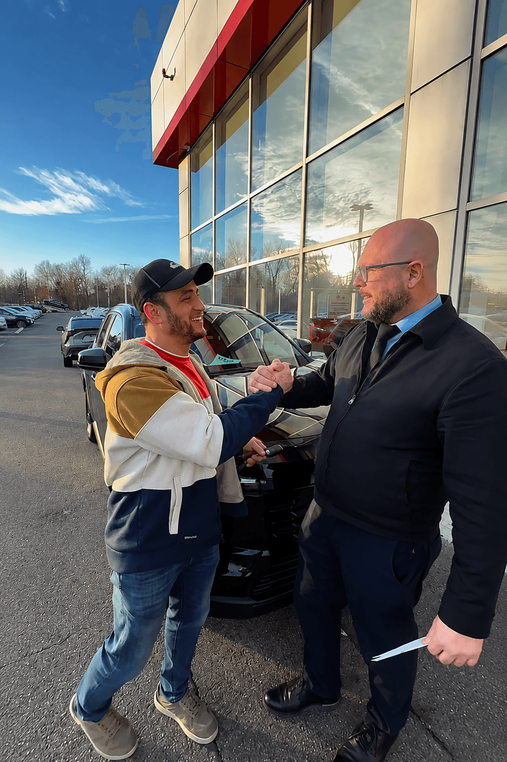 Carlos Campos handing over the keys and greeting a customer at the dealership